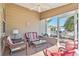 This screened-in porch features comfortable seating, a ceiling fan, and views of the well-manicured yard at 992 Pinewood Pl, The Villages, FL 32162