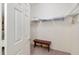 A walk-in closet offering ample shelving and storage space, with a small bench at 992 Pinewood Pl, The Villages, FL 32162