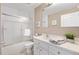 Well-lit bathroom features a shower-tub combo with glass doors and a single sink vanity with neutral countertops at 1037 Willow Dr, Leesburg, FL 34748