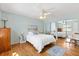 Cozy bedroom with hardwood floors, a ceiling fan, and mirrored closet doors, creating a bright space at 1037 Willow Dr, Leesburg, FL 34748