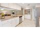 Bright kitchen with white cabinets, stainless steel appliances, and a convenient laundry area at 1037 Willow Dr, Leesburg, FL 34748