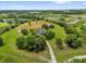 Aerial view of a property with a long driveway leading to the house with lush landscape and pond at 10901 Island Grove Rd, Clermont, FL 34711