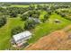 Expansive property featuring a well-maintained lawn, house, garage, and barn surrounded by lush greenery at 10901 Island Grove Rd, Clermont, FL 34711