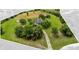 Aerial view of the property showing a long driveway, house, lush landscape, and clearly marked property lines at 10901 Island Grove Rd, Clermont, FL 34711