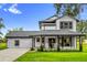 Charming two-story home featuring a welcoming front porch with rocking chairs and landscaped front yard at 10901 Island Grove Rd, Clermont, FL 34711