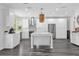 Bright kitchen features white cabinetry, modern appliances, stylish backsplash and kitchen island with pendant lights at 10901 Island Grove Rd, Clermont, FL 34711