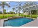 Screened-in pool area featuring a refreshing pool with tile accents and views of palm trees at 10901 Island Grove Rd, Clermont, FL 34711