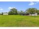 Sprawling green lawn with home, pool, and barn in the distance at 10901 Island Grove Rd, Clermont, FL 34711