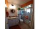 Clean bathroom with a shower, beadboard walls, granite countertop, modern fixtures, and orange accent paint at 11250 Sw 78Th Ct, Ocala, FL 34476