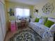 Sunlit bedroom with a daybed, a white desk and a vibrant rug, creating a cozy and inviting space at 11250 Sw 78Th Ct, Ocala, FL 34476