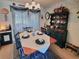 Elegant dining area featuring a chandelier, dining table set for four, and decorative china cabinet at 11250 Sw 78Th Ct, Ocala, FL 34476
