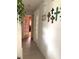 Hallway with decorative wall hangings, light laminate floors and a view into another room with double doors at 11250 Sw 78Th Ct, Ocala, FL 34476