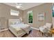 Guest bedroom featuring a queen bed, bright windows, and a comfortable chair at 1172 Fiesta Key Cir, Lady Lake, FL 32159
