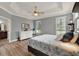 Primary bedroom with tray ceiling, white dresser, and large windows offering natural light at 1172 Fiesta Key Cir, Lady Lake, FL 32159