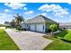 Rear-facing view of home highlighting the attached two-car garage and manicured landscaping at 1172 Fiesta Key Cir, Lady Lake, FL 32159