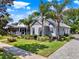 Beautiful home with lush landscaping, complemented by mature palm trees creating a serene and inviting ambiance at 1172 Fiesta Key Cir, Lady Lake, FL 32159