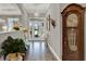Elegant foyer with wood look flooring, a decorative mirror, and a striking grandfather clock at 1172 Fiesta Key Cir, Lady Lake, FL 32159