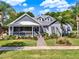 Charming single-story home featuring a inviting front porch, beautiful landscaping and mature palm trees at 1172 Fiesta Key Cir, Lady Lake, FL 32159