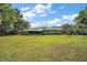 Expansive backyard featuring well-maintained lawn, mature trees, and a screened-in porch, perfect for relaxation and outdoor activities at 1313 Crestview Dr, Mount Dora, FL 32757