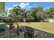 Large grassy backyard surrounded by mature trees and with brick paver patio at 1313 Crestview Dr, Mount Dora, FL 32757
