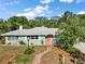 Charming single-story home features a brick walkway and a freshly painted exterior with mature trees at 1313 Crestview Dr, Mount Dora, FL 32757