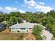 Charming single-story home featuring a light blue facade, white trim, a brick walkway and a colorful door, surrounded by lush greenery at 1313 Crestview Dr, Mount Dora, FL 32757
