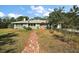 Inviting front yard with a brick walkway, lush greenery, and a well-maintained lawn, creating a warm and welcoming ambiance at 1313 Crestview Dr, Mount Dora, FL 32757