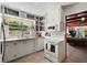 Well-lit kitchen featuring open shelving, bright windows, and classic appliances at 1313 Crestview Dr, Mount Dora, FL 32757