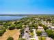 Aerial view of neighborhood homes with a lake view, featuring tree-lined streets at 13319 Via Roma Cir, Clermont, FL 34711