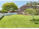 Spacious backyard with a screened pool, white fence and large, mature tree at 13319 Via Roma Cir, Clermont, FL 34711