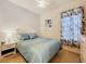 Comfortable bedroom with light blue bedding, a ceiling fan, and a view from the window at 13319 Via Roma Cir, Clermont, FL 34711