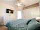 Cozy bedroom with a ceiling fan, closet, and a mounted flat screen television at 13319 Via Roma Cir, Clermont, FL 34711