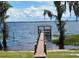 Scenic view of a wooden dock extending into the lake, surrounded by cypress trees at 13319 Via Roma Cir, Clermont, FL 34711