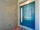 Stylish turquoise front door with sidelight and a video doorbell at 13319 Via Roma Cir, Clermont, FL 34711