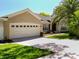 Charming single-story home boasts a well-maintained lawn, lush landscaping and an attached two car garage at 13319 Via Roma Cir, Clermont, FL 34711