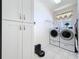 Well-organized laundry room equipped with modern washer and dryer units, plus plenty of storage at 13319 Via Roma Cir, Clermont, FL 34711