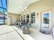 Covered outdoor patio with a dining set, ceiling fan, and access to the screened-in pool area at 13319 Via Roma Cir, Clermont, FL 34711