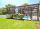 Lush backyard with a screened-in pool, manicured landscaping, and private outdoor living space at 13319 Via Roma Cir, Clermont, FL 34711