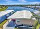 Aerial view of a waterfront single-story home with manicured lawn and dock access at 1401 W Highway 50 # 142, Clermont, FL 34711
