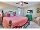 Comfortable bedroom featuring a metal bed frame, ceiling fan, and a colorful dresser at 1401 W Highway 50 # 142, Clermont, FL 34711