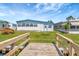 Mobile home backyard with a small dock, green lawn, and partial view of neighboring houses at 1401 W Highway 50 # 143, Clermont, FL 34711