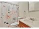 Bathroom features floral shower curtain, white toilet and wood vanity at 1401 W Highway 50 # 143, Clermont, FL 34711