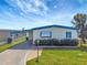 Charming single-story home featuring blue trim, well-manicured lawn, and a carport at 1401 W Highway 50 # 143, Clermont, FL 34711