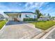 Charming mobile home with blue trim, awning, landscaping, and a well-maintained lawn at 1401 W Highway 50 # 143, Clermont, FL 34711