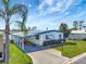 Charming mobile home with white siding, blue trim, and a well-manicured lawn at 1401 W Highway 50 # 143, Clermont, FL 34711