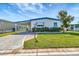A single-story home with a carport, blue trim and a manicured lawn under a blue sky at 1401 W Highway 50 # 143, Clermont, FL 34711