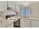 Bright kitchen with white cabinets, countertops, and modern backsplash at 1401 W Highway 50 # 143, Clermont, FL 34711