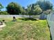 A spacious backyard with green grass, shed, white fence, and a shade tree at 14657 Sw 41St Ave, Ocala, FL 34473