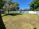 A spacious backyard with green grass, shed, white fence, and a blue house at 14657 Sw 41St Ave, Ocala, FL 34473