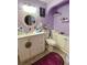 Bathroom features a vanity, toilet, mirror, and decorations, highlighted with purple accents at 14657 Sw 41St Ave, Ocala, FL 34473